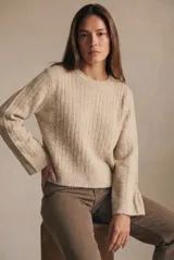 Sweater de punto con textura acanalada vertical, color beige melange, de cuello redondo y manga larga con puños rectos.