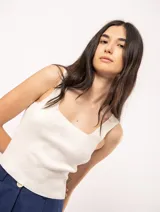 Top tejido color crudo con escote cuadrado y largo a la cintura.