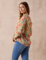Blusa estampada de Zac & Rachel con cuello a la base, escote en V y botones. Tiene un bolsillo aplicado en la parte delantera, mangas largas regulables con presilla y botón, y terminación anudada opcional.