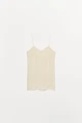 Top lencero de tirantes finos con escote en pico y aplicaciones de encaje a tono en el escote, laterales y bajo. Presenta aberturas laterales en el ruedo.