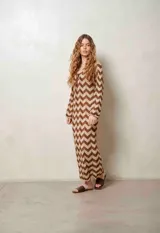 Vestido largo de lurex con diseño de patrón en zigzag en tonos tostado y marrón, escote en V con cordones para atar y mangas largas.