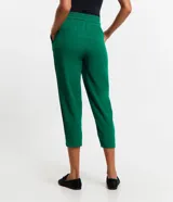 Pantalón de crepé rojo, modelo estilo pijama, de corte fluido, con cintura elástica y lazo de ajuste con terminales metálicas. Cuenta con bolsillos laterales y cierre frontal con cremallera y botón.