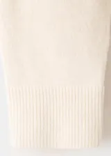 Chaleco de punto color blanco con detalles de líneas negras en los hombros y sisas, cuello alto y diseño holgado.