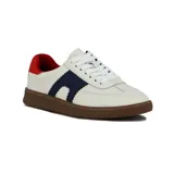 Zapatilla deportiva de caña baja, color blanco, con suela de goma marrón. Presenta detalles en azul marino con borde festoneado en el lateral y refuerzo en el talón de color rojo. Cordones blancos.