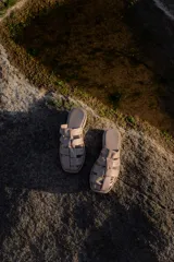 Sandalias bajas color beige con tiras de cuero entretejidas.