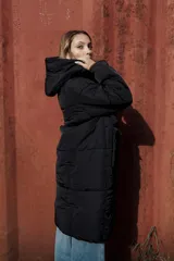 Campera larga acolchonada color marrón, con diseño midi, capucha amplia, cierre frontal con cremallera y broches, y bolsillos delanteros con tapa.