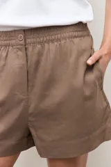 Short de lino color marrón topo, con cintura elástica y botón frontal.