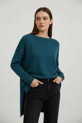 Sweater holgado de punto color verde azulado, con cuello a la base y manga larga.
