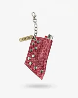 Porta encendedor de cuero con estampado efecto crocco en color fucsia, decorado con tachas metálicas y una cadena con dije identificatorio.