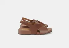 Sandalia de cuero color café con tiras cruzadas en el empeine, talón con elástico interno y plantilla acolchada. Tiene una plataforma ligera y un tacón de 3cm.