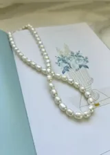 Collar corto de perlas de río blancas con cierre plateado.