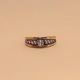 Anillo de plata y oro con diseño ancho, presenta una hilera central de circonias brillantes sobre un fondo oscuro, destacando una piedra principal más grande al centro.