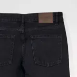 Pantalón de jean negro de corte recto, con bolsillos delanteros y traseros.