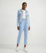 Camisa cropped de jeans celeste con cuello solapa, abotonada al frente, con bolsillos delanteros, desgastes y barra redondeada.