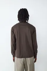 Camiseta de manga larga con cuello redondo y corte relajado, confeccionada en algodón de color marrón oscuro.