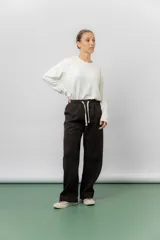 Pantalon de corte relajado y pierna recta, confeccionado en corderoy liviano color marron oscuro. Cuenta con cintura elastizada y lazo ajustable en el frente.
