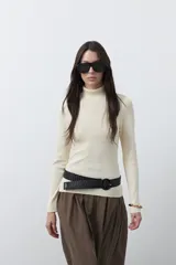 Polera de manga larga y cuello alto, confeccionada en tejido de punto fino, con un ajuste ceñido al cuerpo.