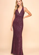 Vestido largo sin mangas confeccionado íntegramente en tela con lentejuelas brillantes. Presenta un escote en V profundo, ajuste entallado en la cintura y falda con caída fluida.