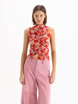Top de punto rojo sin mangas, con escote alto tipo polera y detalle de frunce central en el frente, con estampado floral full print.