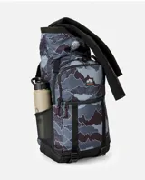 Mochila Rip Curl modelo Dawn Patrol 30L Search, de diseño estampado tipo camuflado en tonos gris, azul y negro. Cuenta con compartimento principal tipo rollo, bolsillos frontales con cierre, bolsillo lateral de malla para botella, correas ajustables y base negra reforzada.