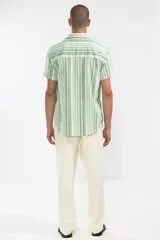 Pantalón de lino color crema, de corte recto y fit relajado. Tiene cintura elástica con cordón de algodón, bolsillos laterales y traseros.