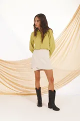 Camisa verde lima de manga larga con puños abullonados y botones dorados.