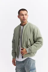 Campera tipo bomber de nylon color verde oliva, con cierre frontal, cuello, puños y cintura elastizados.