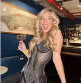 Body entero de corte ajustado confeccionado en tejido mesh transparente. Presenta un diseño con copas estructuradas y aplicaciones de pedrería brillante distribuidas estratégicamente a lo largo de la prenda, creando un efecto visual lineal y sofisticado.