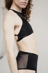 Top negro confeccionado en lycra y tela de malla semitransparente, con diseño de cuello halter y ajuste posterior.
