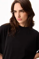 Remera básica de algodón color negro, con cuello redondo y detalle de bordado en el hombro.