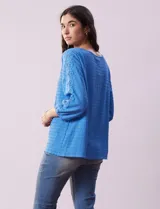 Blusa amarilla texturada con escote redondo y mangas 3/4 con puño elastizado. Aplique de broderie en escote y mangas. Marca Ruby Rd.