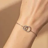 Pulsera de plata 925 con cadena fina y dos aros entrelazados, uno de ellos adornado con circonias.