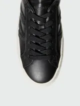 Zapatillas de piel negras de caña baja, con suela plataforma blanca. Presentan tres franjas laterales con acabado brillante o glitter negro.