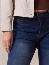 Jean de tiro alto, color azul, con corte bootcut y bolsillos delanteros y traseros.