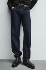 Bota Chelsea de cuero marrón, con punta fina y elásticos laterales oscuros. Posee un tirador trasero y un taco bajo y cuadrado.