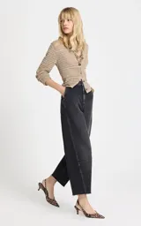 Jean de tiro alto con corte ancho y pierna recta, confeccionado en denim de lavado oscuro. Presenta costuras horizontales en la parte frontal de las rodillas, bolsillos traseros, cierre frontal con cremallera y botón, y dobladillo deshilachado.