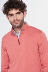 Buzo de tejido fino en hilo de algodón, color rosado, con cuello alto y cierre frontal parcial con detalle en cuero. Presenta puños y ruedo acanalados y un pequeño logo bordado en el pecho.