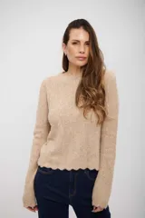 Buzo de tejido de punto color beige, con cuello redondo, manga larga y terminación de ruedo con diseño ondulado.