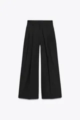 Pantalón de tiro medio con corte recto y holgado. Presenta pinzas en el delantero, trabillas para cinturón y cierre frontal con cremallera, botón y gancho metálico. Incluye bolsillos laterales y detalle de tapetas en la parte trasera.