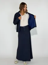 Pollera larga de denim color azul oscuro, corte evasé y ruedo desflecado.