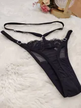 Tanga de diseño sofisticado confeccionada en una combinación de microtul transparente y encaje. Presenta un corte tipo colaless con tiras elásticas regulables en la cintura y laterales, permitiendo un ajuste personalizado. El panel frontal combina una sección de encaje con una base de microtul y un refuerzo de algodón para mayor confort.