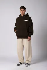 Buzo canguro oversize de algodón frisa premium con efecto lavado en color negro. Presenta capucha, bolsillo frontal tipo canguro y estampa blanca en el pecho.