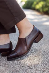 Zapato de cuero marrón con puntera fina y pequeño taco cuadrado.