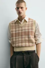 Chaleco relaxed fit de punto tejido en hilatura de algodón, con diseño a cuadros en tonos marrón y beige, cuello en V y acabados en rib en el cuello, las sisas y el ruedo.