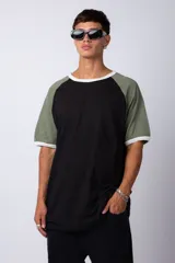Remera estilo raglán color blanco en el cuerpo, con mangas en tono tostado y ribetes en color verde militar en el cuello y los puños.