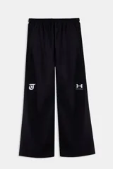 Pantalón jogger negro de corte ancho y relajado, perteneciente a la colección Tini x Under Armour. Cuenta con cintura elástica con cordón ajustable y detalles de logotipos estampados en blanco en las piernas.