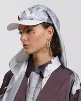 Gorra con visera curva y sistema de ajuste trasero. Incluye pañuelo integrado de seda con estampado abstracto en tonos grises y blancos.