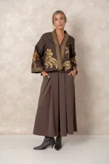 Chaqueta corta estilo kimono color chocolate, con bordados florales en tono dorado en el frente y las mangas. Presenta guardas decorativas bordadas a lo largo del cuello, la apertura frontal y los puños.