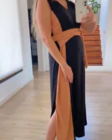 Vestido largo de corte imperio, con paneles verticales en color negro, blanco y ocre. Incluye lazo de tela ocre para ajustar debajo del busto.