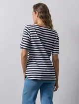 Remera de algodón a rayas horizontales blancas y negras, con cuello redondo y mangas cortas con aberturas entrelazadas.